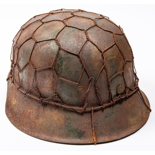 164 - A Third Reich M1943 raw edge pattern steel helmet, in combat condition, traces of SS decal, wire net... 