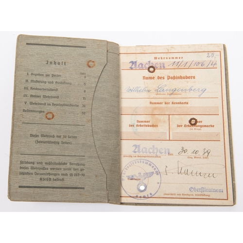 101 - A Third Reich Wehrpass, two similar Arbeitsbuch, and a Dienstausweis. GC £30-50