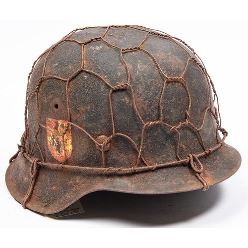 156 - A Third Reich M1943 raw edge steel helmet, in combat condition with traces of 