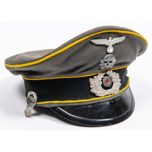 161 - A well made copy of a Third Reich cavalry officer's peaked cap, grey with yellow piping, alloy badge... 