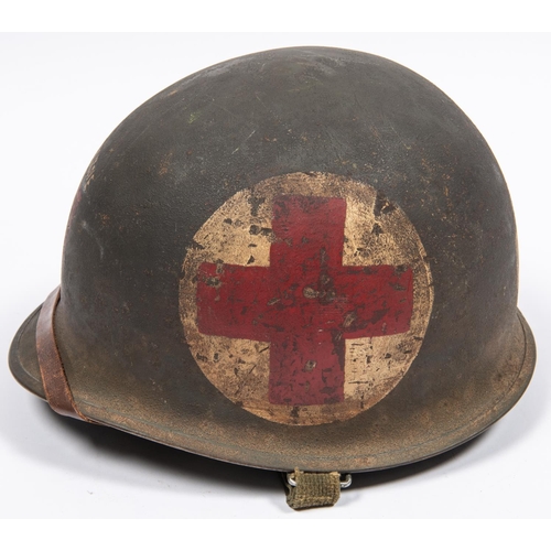 316 - A WWII American medic's steel helmet, with webbing chinstrap and fibre liner, the front painted with... 