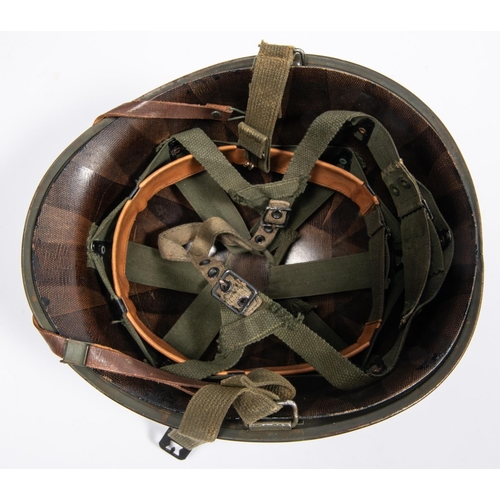 316 - A WWII American medic's steel helmet, with webbing chinstrap and fibre liner, the front painted with... 