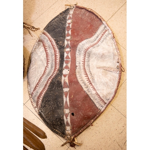 340 - An East African painted shield, possibly Masai, 2 African drums (1 badly damaged), 2 Masai lion spea... 