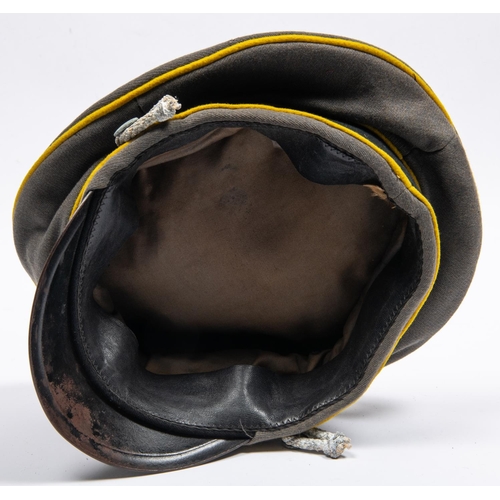 169 - A well made copy of a Third Reich cavalry officer's peaked cap, grey with yellow piping, alloy badge... 