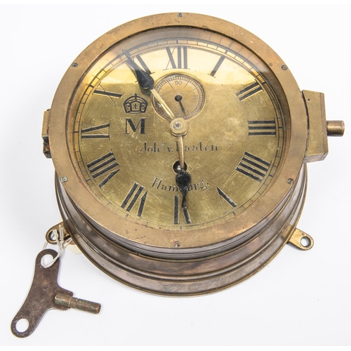 67 - An Imperial German ship's bulkhead clock, the brass face having black Roman numerals, maker's name 