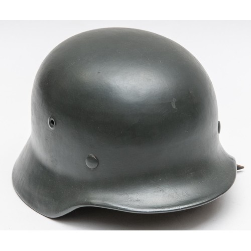 102 - A Third Reich M35 steel helmet, repainted at an early date with grey paint, complete with lining and... 