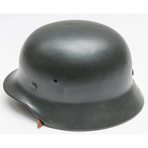 102 - A Third Reich M35 steel helmet, repainted at an early date with grey paint, complete with lining and... 