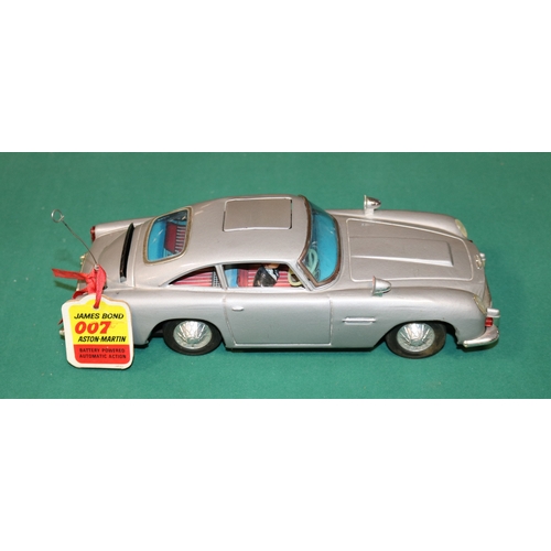 101 - James Bond tinplate Aston Martin toy by Gilbert of  America. Battery operated mechanism operates fla... 