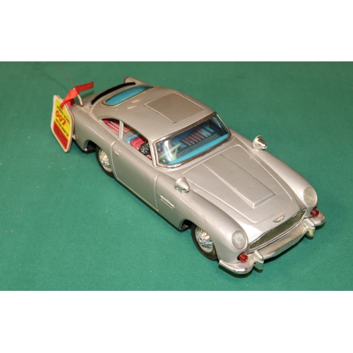 101 - James Bond tinplate Aston Martin toy by Gilbert of  America. Battery operated mechanism operates fla... 