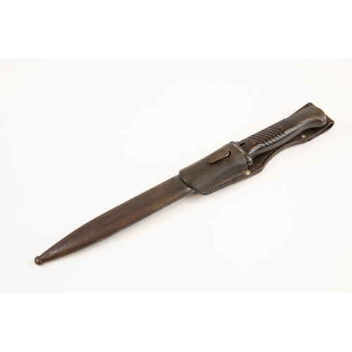 101 - A WWII German K98 bayonet, with brown bakelite grips, in its scabbard with leather frog, the bayonet... 