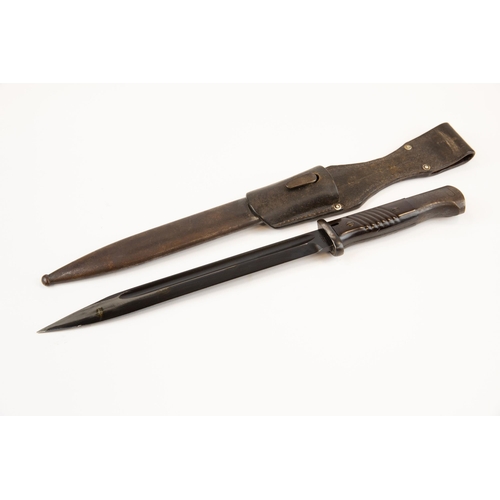 101 - A WWII German K98 bayonet, with brown bakelite grips, in its scabbard with leather frog, the bayonet... 