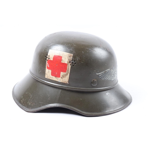 74 - A German WWII Luftschutz helmet, decal to front and red cross badge painted to side, chinstrap detac... 