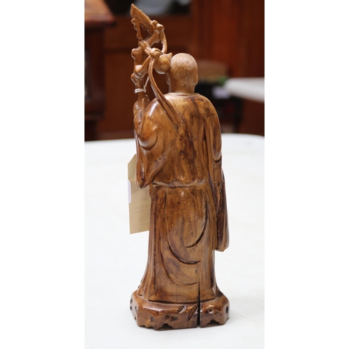 410 - A carved wooden figure of an Oriental gentleman holding a branch, with a small boy below holding wha... 