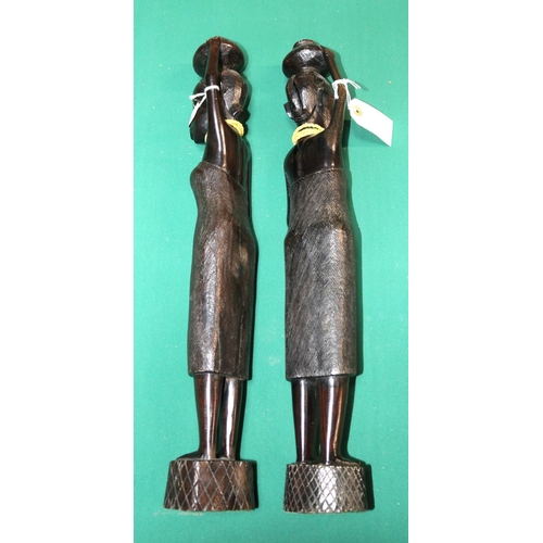 415 - A pair of carved solid ebony tribal woman standing holding containers to their heads. These are from... 