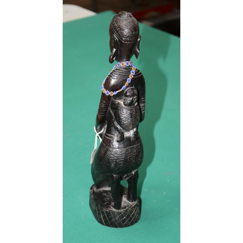 421 - Hand carved figure of a tribal lady with baby on her back, Kneeling down holding a container, Damage... 