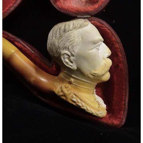 31 - An early 20th century meerschaum pipe, the bowl in the form of Lord Kitchener's head, in its red vel... 