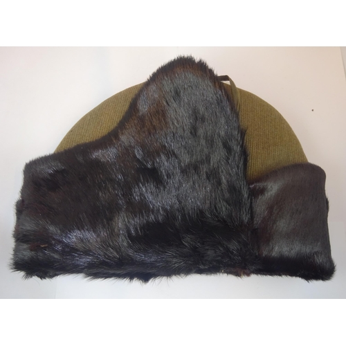 274 - A WWII British Infantry cold weather cap, khaki cord body with sealskin ear flaps, quilted lining wi... 