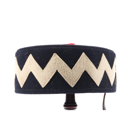 275 - An Edwardian OR's pill box hat, black with zig zag white facings, (2nd Dragoons ), and red button, w... 