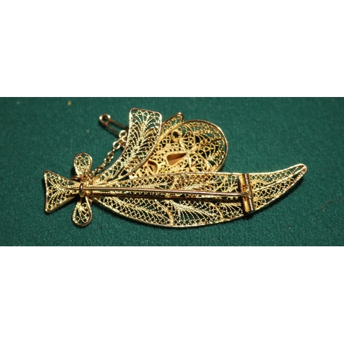 42 - A possibly 18K gold unmarked yellow metal filigree  brooch, depicting what looks like leaves tied wi... 