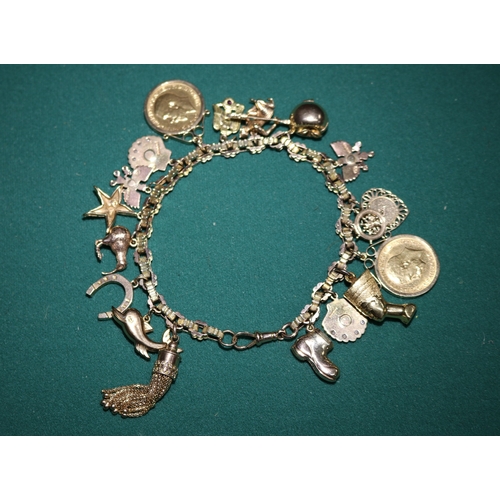 45 - A Very impressive 9ct gold hallmarked  charm bracelet with 16 charms, includes 2 shell charms with s... 