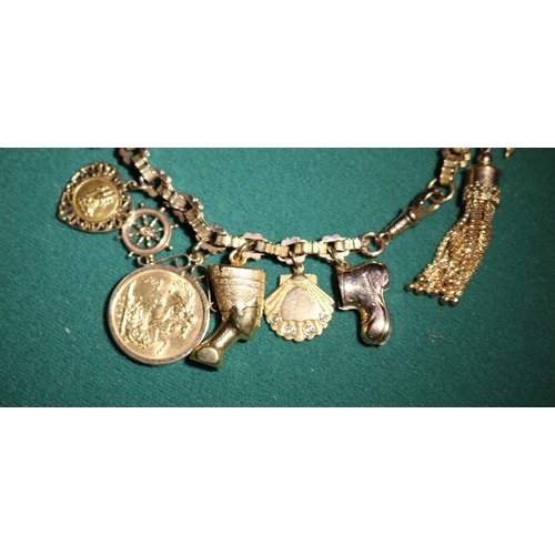 45 - A Very impressive 9ct gold hallmarked  charm bracelet with 16 charms, includes 2 shell charms with s... 