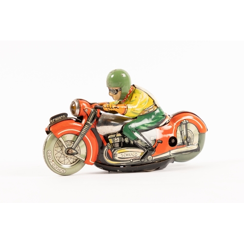 356 - A Schuco clockwork tinplate racing motorcycle. In red with unpainted tank, rider in yellow and green... 