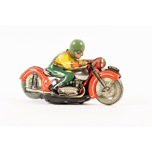 356 - A Schuco clockwork tinplate racing motorcycle. In red with unpainted tank, rider in yellow and green... 