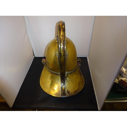 18 - A good original Fireman's brass helmet, with chin chain, badge, rosettes, and leather lining. GC £20... 