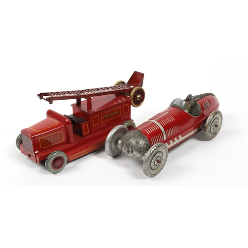 394 - A LOUIS MARX stream lined tin plate wind up racing car in red with driver and No.410 to rear fin. Re... 