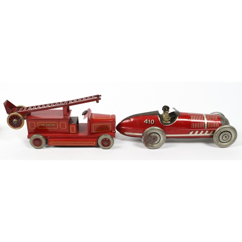 394 - A LOUIS MARX stream lined tin plate wind up racing car in red with driver and No.410 to rear fin. Re... 