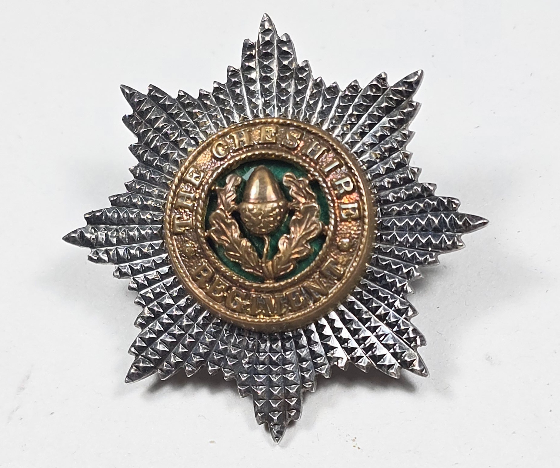 The Cheshire Regiment. An officer’s forage cap badge in gilt and silver ...