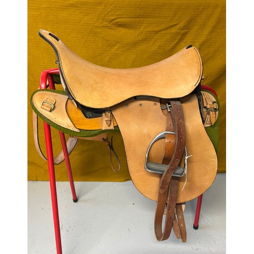 239 - A leather saddle with prominent iron frame, leather stencilled JCCO 1988 429 5127 TS, nickel stirrup... 