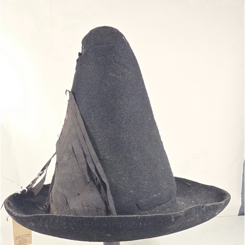 418 - An early (18thcentury?) black felt hat, with conical skull, upturned brim and remains of silk facing... 