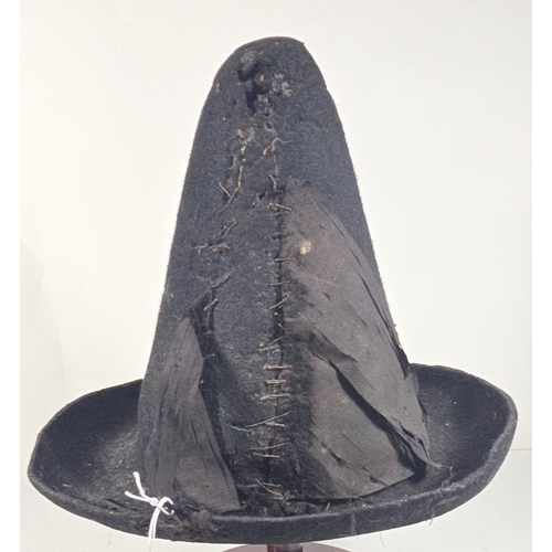 418 - An early (18thcentury?) black felt hat, with conical skull, upturned brim and remains of silk facing... 