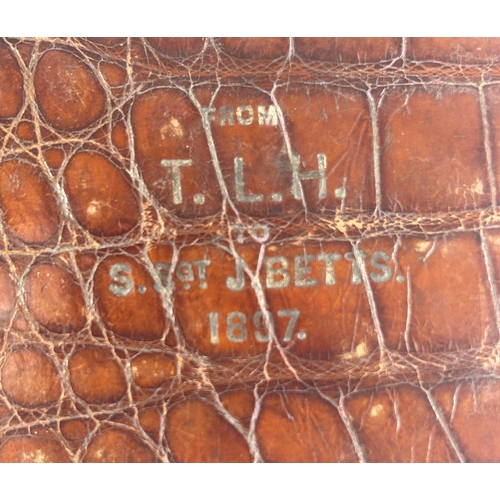 27 - A Victorian crocodile leather card case with silver corner mounts and metal frame, embossed with own... 