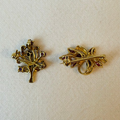 56 - Two Small 9ct Gold Brooches in a leaf form
One ruby set, one diamond and purple sapphire set
4.1g co... 