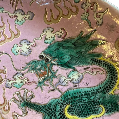 221 - A Large Chinese pink-ground famille rose enamelled 'dragon dish', Kangxi mark and probably of the pe... 