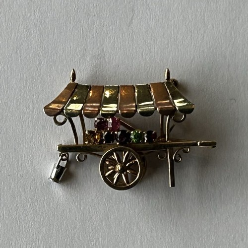 15 - 9ct Gold Novelty Brooch in the form of a flower seller's barrow with bi-coloured canopy, and hung wi... 