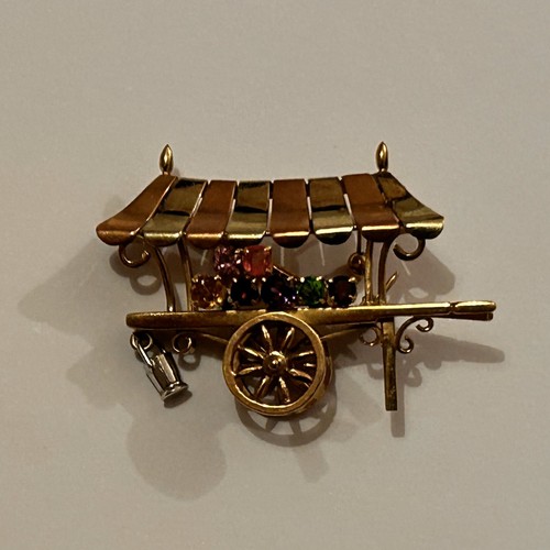 15 - 9ct Gold Novelty Brooch in the form of a flower seller's barrow with bi-coloured canopy, and hung wi... 