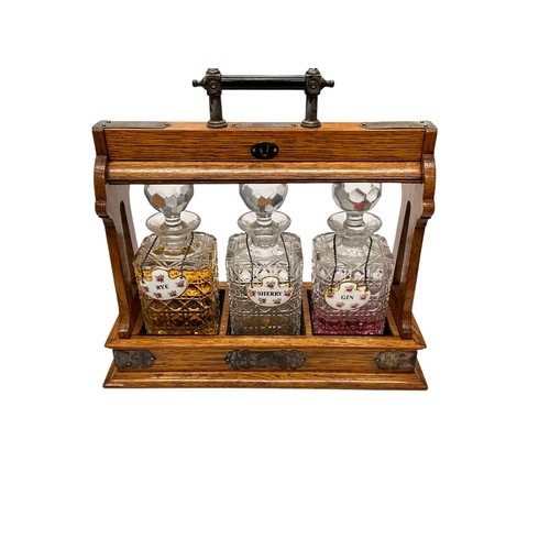 10 - An 20th Century Oak and Silver Mounted Three Bottle Tantalus, Complete with Key, 38x13x33cm 
also ce... 