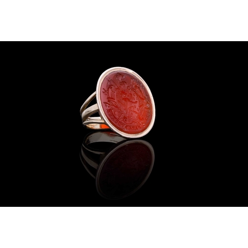 238 - A CARNELIAN INTAGLIO SIGNET RING IN GOLD engraved with an intricate coat of arms centred with lion r... 