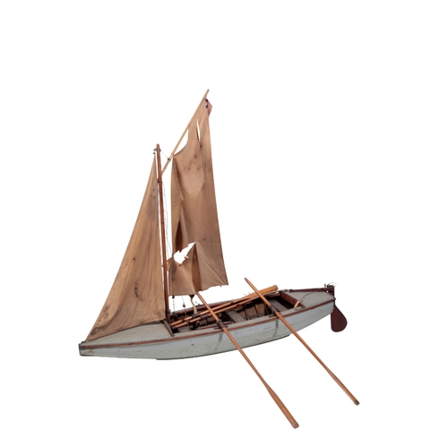 221 - A 1930'S MODEL WOODEN SAILING BOAT with a blue painted hull and worn brown sails, 98cm long and 88cm... 