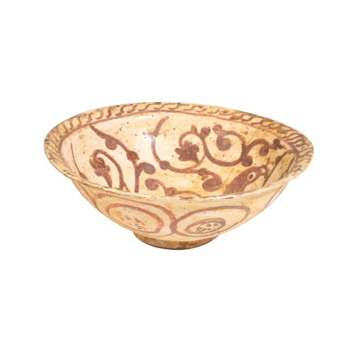 130 - AN ISLAMIC GLAZED-POTTERY BOWL, POSSIBLY 12TH CENTURY painted in earth tones with a stylised bird an... 