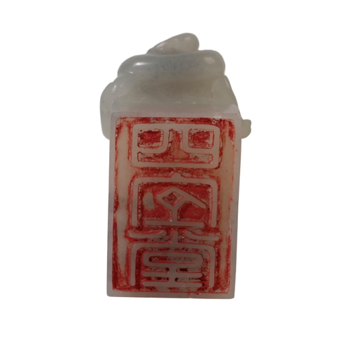 53 - A CHINESE PALE CELADON SEAL carved with a mythical beast, the underside of the rectangular base with... 