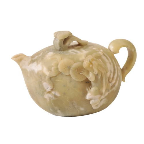 62 - A CHINESE GREEN SOAPSTONE TEAPOT the gourd-shaped body mottled in white and carved with a coin toad ... 