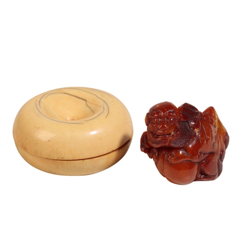 64 - A CHINESE AMBER BUDDHISTIC LION, QING, together with a small ivory box in the form of a fruit, early... 