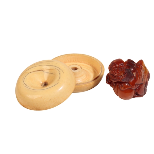 64 - A CHINESE AMBER BUDDHISTIC LION, QING, together with a small ivory box in the form of a fruit, early... 