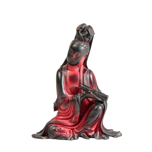 72 - A CHINESE RED 'LACQUER' SEATED GUANYIN the underside with seal marks and inscription, 11cm high