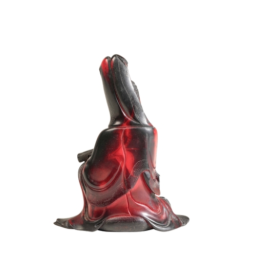 72 - A CHINESE RED 'LACQUER' SEATED GUANYIN the underside with seal marks and inscription, 11cm high