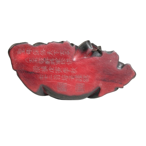 72 - A CHINESE RED 'LACQUER' SEATED GUANYIN the underside with seal marks and inscription, 11cm high